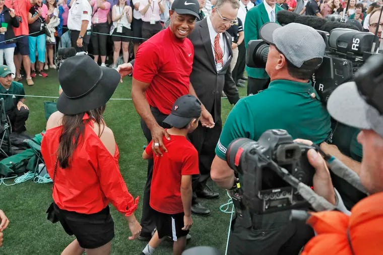 Tiger Woods smiles as he and his son, Charlie, walk off the course on Sunday at Augusta National.