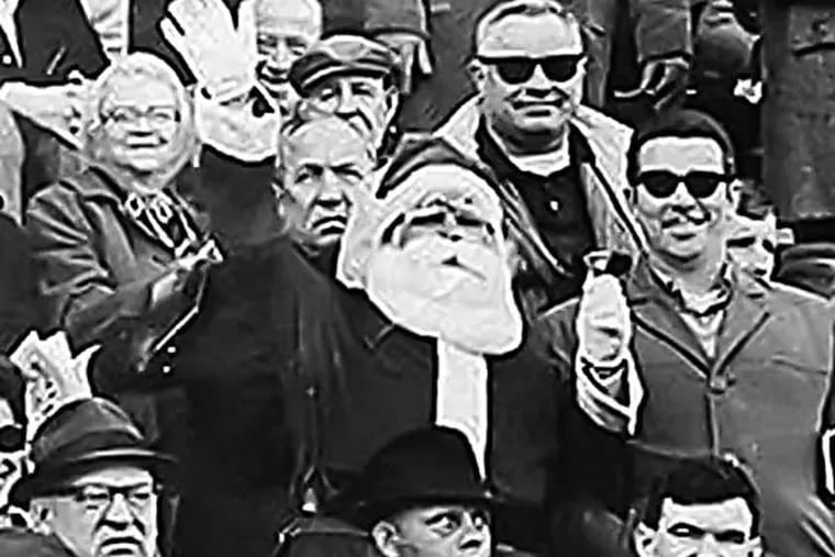 Frank Olivo, center, is shown in this 1967 photograph wearing his Santa suit at an Eagles game. (AP photo)