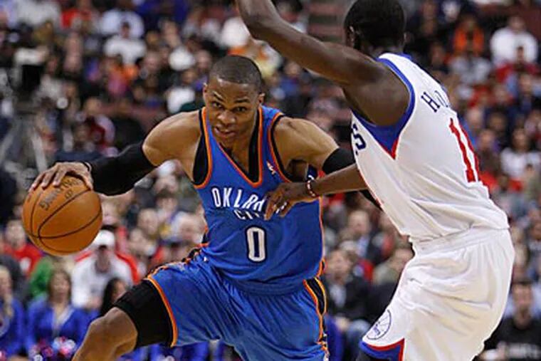Thunder guard Russell Westbrook drives on Sixers point guard Jrue Holiday. (Ron Cortes/Staff Photographer)