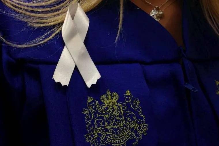 White ribbons are by graduates at Hofstra University's commencement in honor of Andrea Rebello.