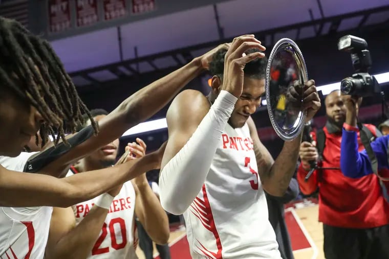 Imhotep’s Justin Edwards is congratulated by teammates for winning MVP of the Public League championship game against West Philly at the Liacouras Center on Feb. 25.
