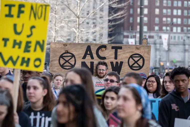 Daoud Steele, 35, holds up a sign while listening to speeches during the global climate strike at City Hall in Philadelphia on March 15. Students from around the Philadelphia region along with people of all ages came together for the global movement.