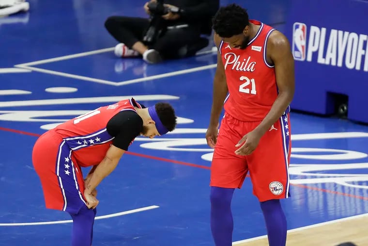 Sixers center Joel Embiid and guard Seth Curry look down late in the game.
