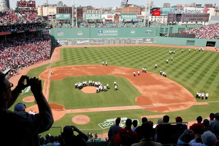 Former Red Sox players, managers, and coaches walk onto the field during the ceremony marking the 100th year of Boston's Fenway Park. It opened April 9, 1912.
