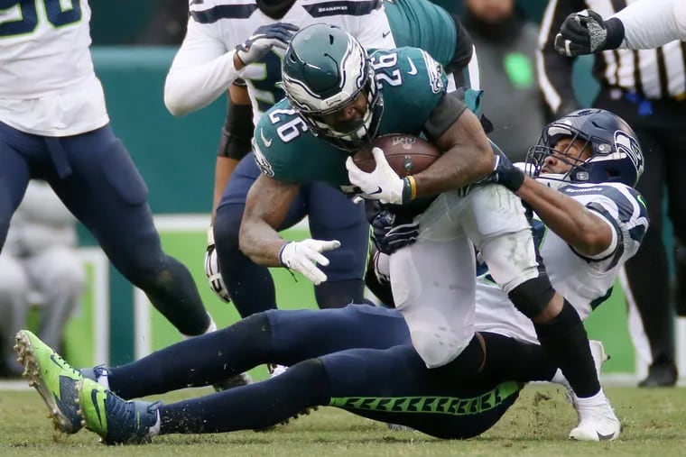 Seattle Seahawks linebacker K.J. Wright pulls down Eagles running back Miles Sanders in Sunday's game at the Linc. Sanders rushed for 63 yards on 12 carries, but had just three catches for 23 yards.