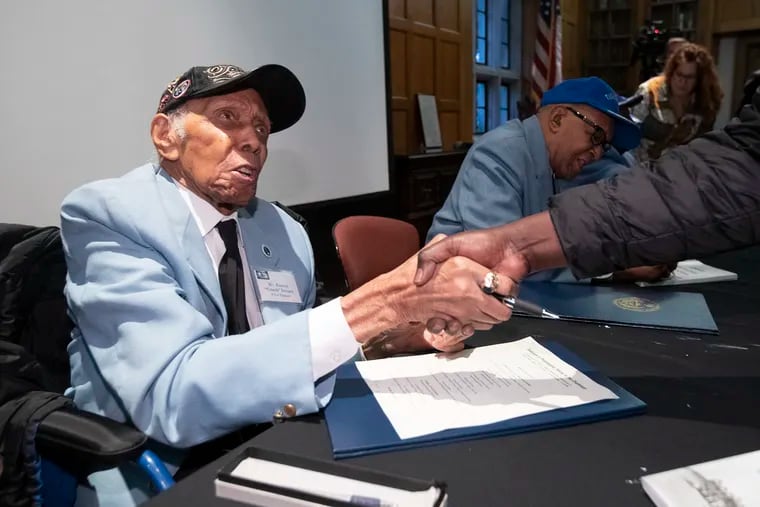 Tuskegee airman and instructor Roscoe “Coach” Draper, 100, a native of Haverford Township, shakes a hand last week at West Chester University after signing a new book about his historic African-American World War II unit.