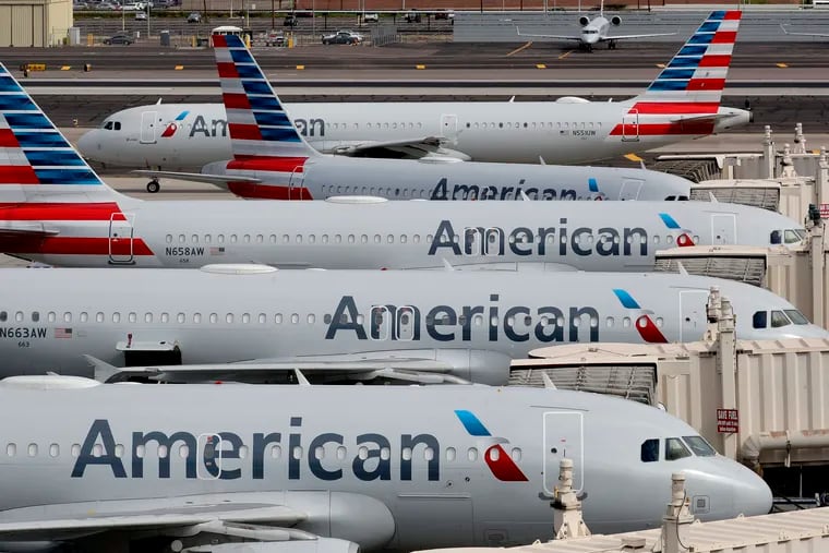 In this March file photo, American Airlines jets sit idly at their gates as a jet arrives at Sky Harbor International Airport in Phoenix.