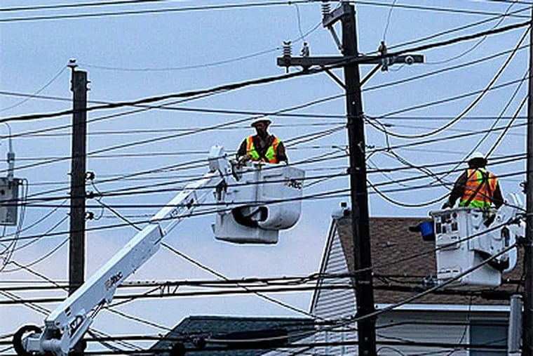 Utility crews work on power lines in Ship Bottom. "We had massive damage to our infrastructure," said a spokesman for Jersey Central Power & Light Co. (Patrick Semansky / Associated Press)