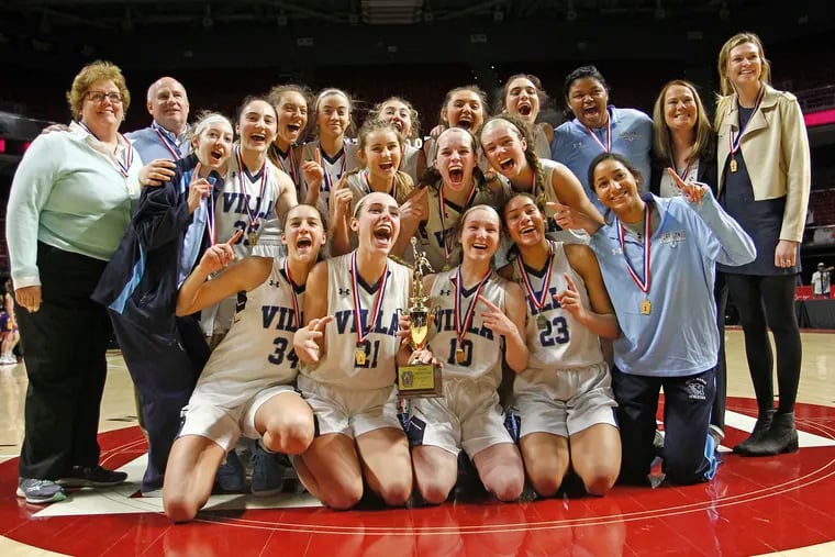 Villa Maria players and coaches pose with the trophy after winning the District 1 Class 5A girls basketball championship game.