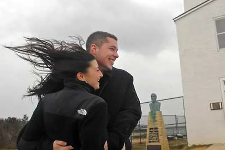 Penn State student Michelle Rosenberg and Kurt Covine are blown by the storm winds as they visit newly refurbished Barnegat Lighthouse on Wednesday. The lighthouse was closed to visitors because of the strong winds. (Tom Gralish  /  Staff Photographer)