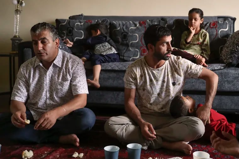 Mohammad Sadiq Sadeed (left) and Mohammad Sabour Khalil speak about access to health care while their children sit behind them in the living room of Sadeed’s Northeast Philadelphia home. Sadeed has been living in the U.S. since 2019, while Khalil arrived from Afghanistan with his family in early August.