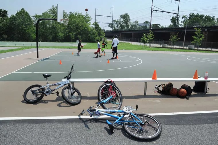 On the Seventh Street basketball courts in Chester, Zain Shaw, a coach and trainer, works with children. Many see the lessons learned there - both athletic and personal - to help in getting them out of the beleaguered city.