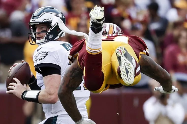Eagles quarterback Carson Wentz eludes Washington Redskins inside linebacker Mason Foster during the third-quarter on Sunday.