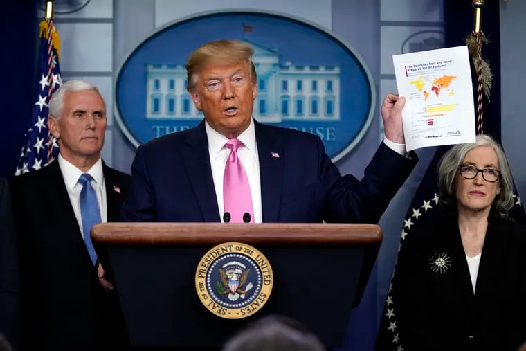 President Donald Trump, with members of the President's Coronavirus Task Force, holds a paper about countries best and least prepared to deal with a pandemic, during a news conference in the Brady Press Briefing Room of the White House, Wednesday, Feb. 26, 2020, in Washington.