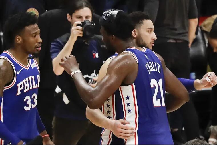 Sixers center Joel Embiid, guard Ben Simmons and forward Robert Covington celebrate their 106-102 win over the Heat in game four of the first round of the playoffs on Saturday.