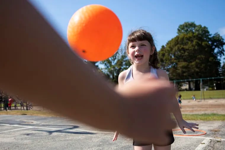 First graders Kylie Smith, 6, right, and Eden Knappick, 6, left, play a game taught by Curt Hinson called hoop ball at McKinley Elementary. Hinson, who goes by "Dr. Recess," visited the school Thursday to teach kids recess-appropriate games.