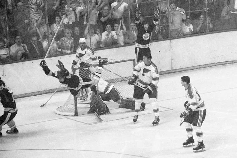 Bobby Orr flies through the air after driving the winning goal past Blues' goalie Glenn Hall in Game 4 of the 1970 Stanley Cup Final.