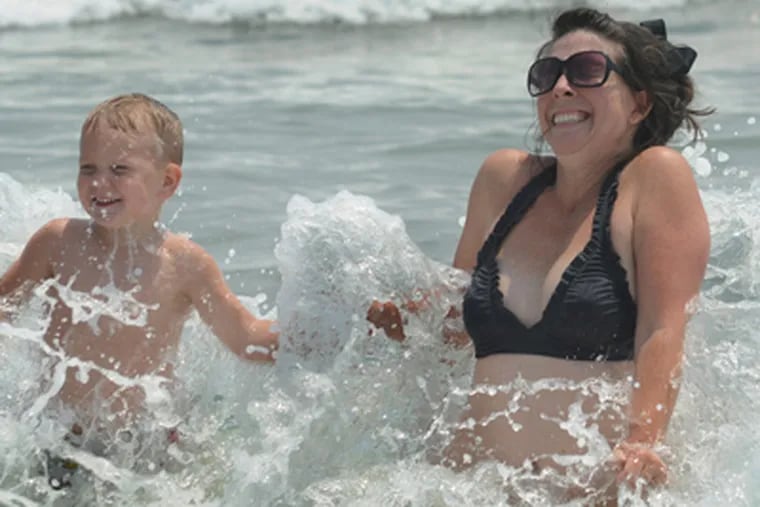 Tracey Willey of Sicklerville and son Bryce enjoy the weather that has helped make this a big summer for Shore businesses. (April Saul / Staff Photographer)
