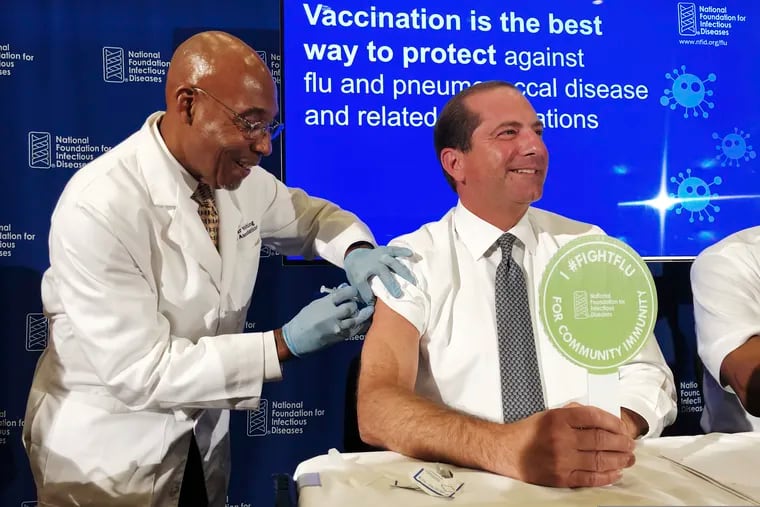 B.K. Morris, a nurse with MedStar Visiting Nurses Association, gives a flu shot to Secretary of Health and Human Services Alex Azar during a news conference in Washington on Sept. 26. (AP Photo/Lauran Neergaard)