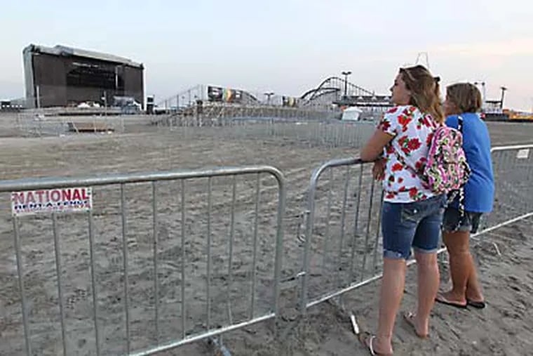 Tori Nazar, 12, left, and her mother, Michelle Nazar, right, both from Pennsville linger at the outskirts of the gates set up to keep people out of the venue until tomorrow's concert by Kenny Chesney on the beach at Wildwood, NJ.   ( MICHAEL BRYANT / Staff Photographer )