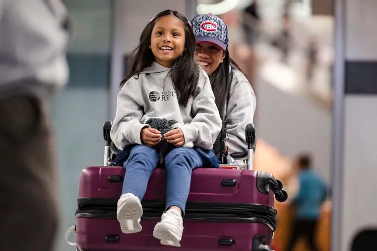 Vanessa Rodel and her 7-year-old daughter Keana exit Lester B. Pearson Airport in Toronto on Monday, March 25, 2019. The Filipino woman who helped shelter former NSA contractor Edward Snowden when he fled to Hong Kong has been granted refugee status in Canada. (Christopher Katsarov/The Canadian Press via AP)