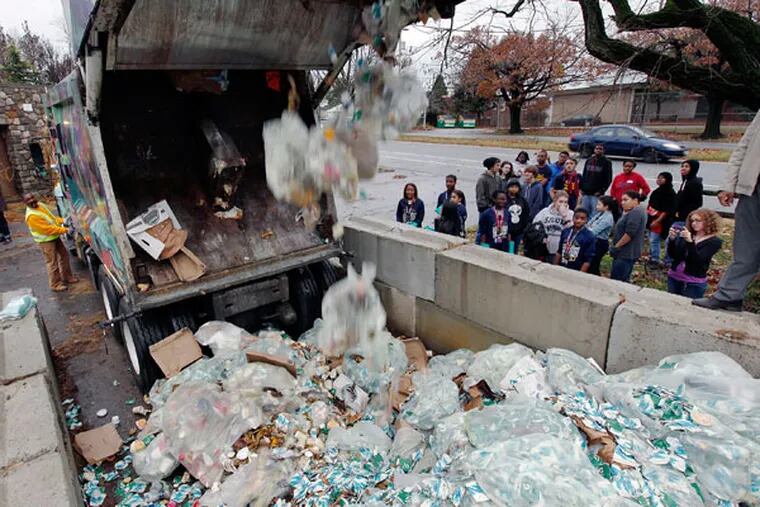 Students at W.B. Saul High School watch a Philadelphia city trash truck unload waste from the Philadelphia Marathon for composting at the farm near the high school.