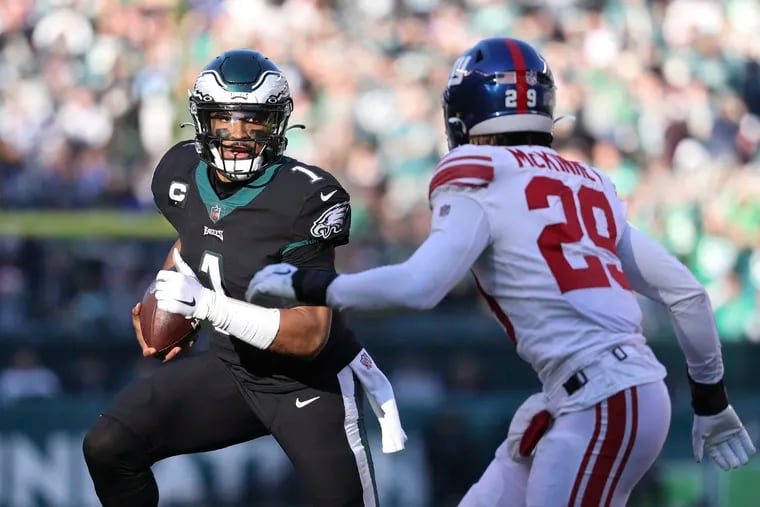 Eagles quarterback Jalen Hurts running with the football against New York Giants free safety Xavier McKinney on Sunday.