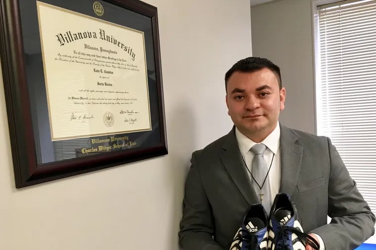 Attorney Luis Canales, a Villanova University law-school graduate now running a legal practice in Cherry Hill, with the shoes he wore while walking from Honduras to Texas. The old Adidas are precious to him.