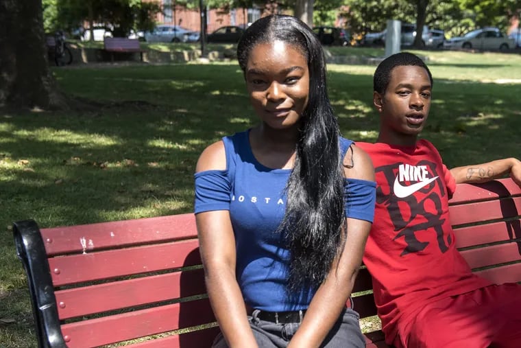 Cori Dixon, 17, left, and Christopher Jones, also 17, sit in Saunders Park in West Philadelphia. Both educate others on homelessness, which they have experienced. HEATHER KHALIFA / Staff Photographer