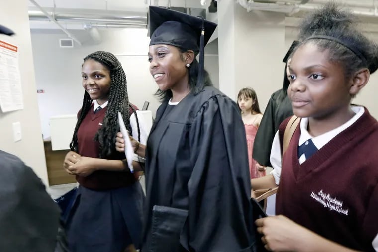 Kellie Woods (center), 42, of Atco, prepares with daughters Hannah Woods (left) ,15, and Canaah Woods, 13, prior to the graduation ceremony of the inaugural class of the LEAP/Rowan Parent University for Adult Learning in Camden on June 1, 2016.