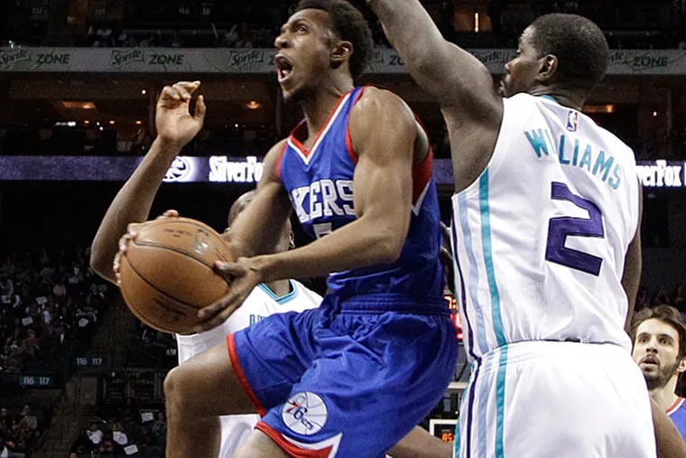 Philadelphia 76ers' Ish Smith, left, drives past Charlotte Hornets' Marvin Williams, right, during the first half of an NBA basketball game in Charlotte, N.C., Saturday, April 4, 2015. (AP Photo/Chuck Burton)
