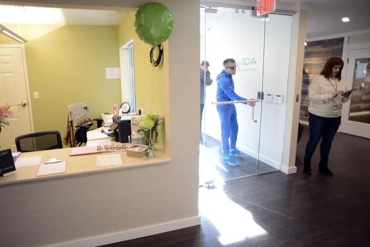 Patient Robert Consulmagno arrives for his appointment as Chris Visco (right) stands by the door at TerraVida Holistic Center, which is one of the first medical marijuana dispensary's in Pennsylvania to open Saturday, February 17, 2018 in Sellersville, Pennsylvania. (WILLIAM THOMAS CAIN / For The Inquirer)