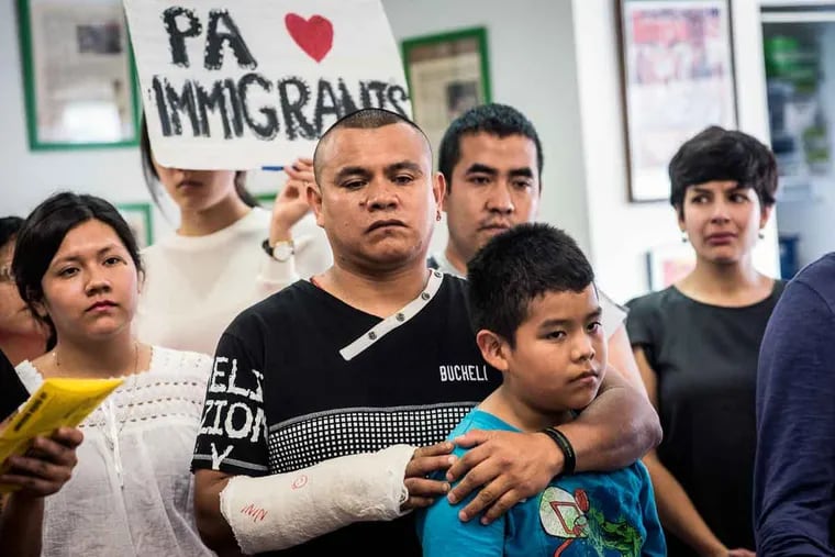 Carlos Rojas holds son Michael, 11, during a news conference at which activists and immigrants voiced their opinions on the 4-4 Supreme Court ruling.