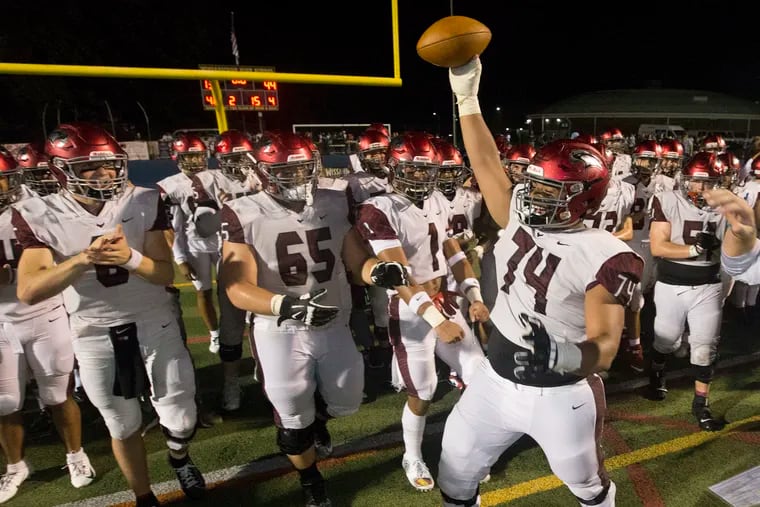 Casey Stephenson, right, (74) of St. Joseph's Prep holds up the game ball after it was presented to the offensive line.  St. Josephâ€™s Prep defeated La Salle 44-13 on Sept. 28, 2019.