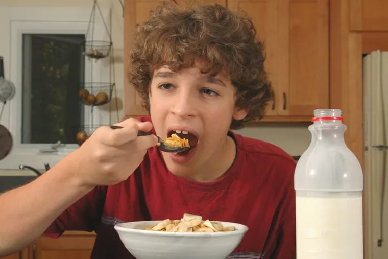 Teen eating cereal for breakfast.