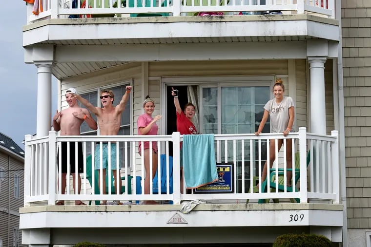 Recently graduated students from Kennett High School in Chester County wave to friends, from the second floor balcony of the house they rented for the week in Wildwood June 13, 2018, during "Senior Week."