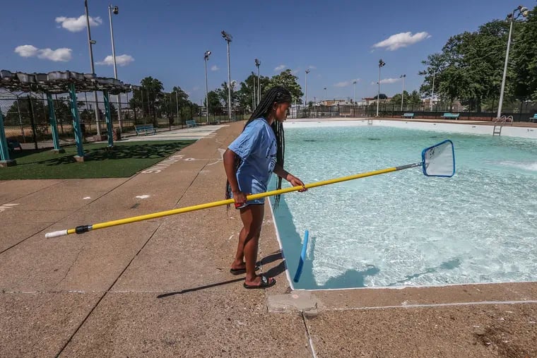 The Lawncrest pool gets filled with water as Taylor Bennett, 18, skims leaves on Friday, June 17, 2022.