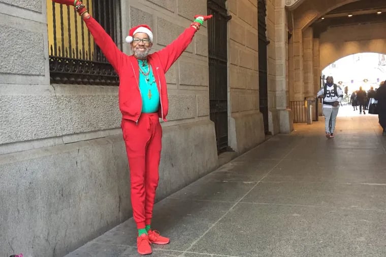 Matt Hopkins, 71, is full of holiday spirit as he dances to Christmas music for passersby at City Hall.