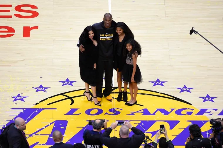 Los Angeles Lakers' Kobe Bryant poses for pictures with his wife Vanessa, left, and daughters Natalia, second from right, and Gianna as they stand on the court after an NBA basketball game against the Utah Jazz, in Los Angeles in 2016.