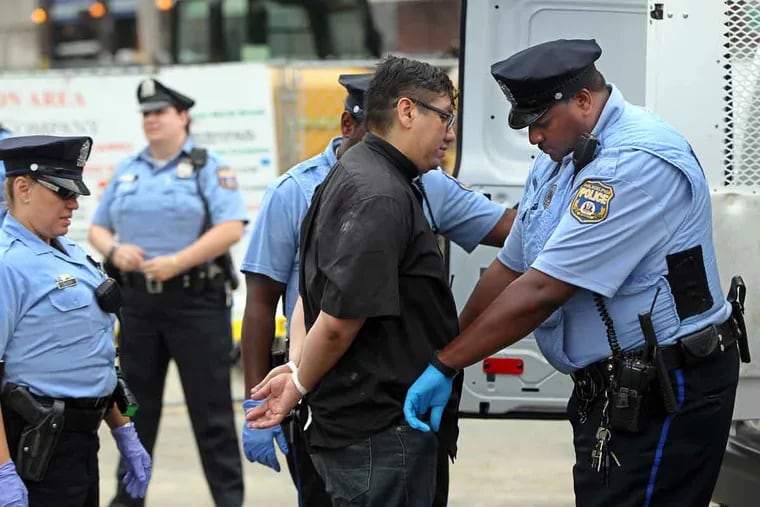 The Rev. Adan Mairena, pastor at West Kensington Ministry, is arrested by Philadelphia police on Tuesday after he and three other immigration protesters blocked traffic for over an hour over the Supreme Court ruling on immigration.