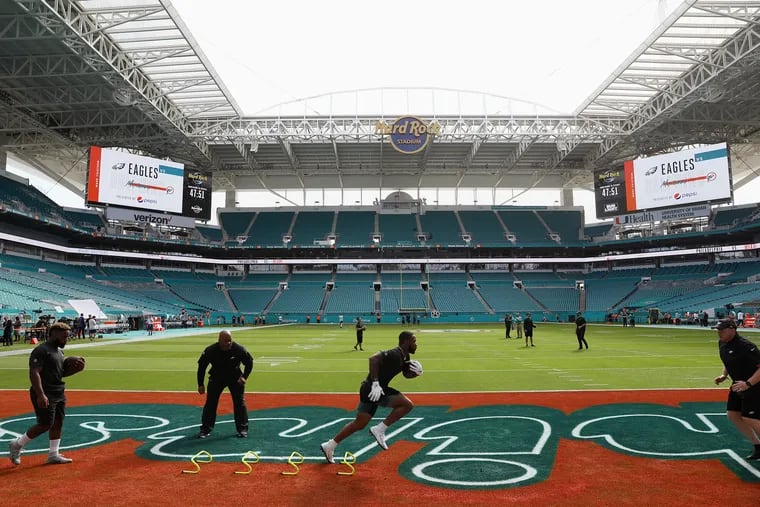 Eagles running back Miles Sanders, center, warms up with running back Boston Scott, left, and assistant coach Duce Staley, second from left, before a game at Hard Rock Stadium in Miami Gardens, Fla., on Sunday, Dec. 1, 2019.
