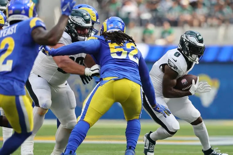 Eagles running back D'Andre Swift attempts to run for a second-quarter first down with Landon Dickerson blocking Los Angeles Rams defensive tackle Larrell Murchison at SoFi Stadium in Inglewood, California on Sunday, Oct. 8, 2023.