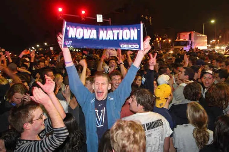 Hundreds of fans jam Lancaster Avenue in front of Villanova University after the Wildcats' victory. Holding his banner high among them is student John McCoey of Philadelphia.