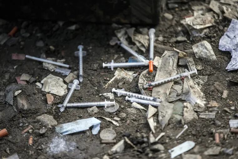 Used needles litter the ground at an open-air drug market along Conrail train tracks in the Kensington section of Philadelphia.