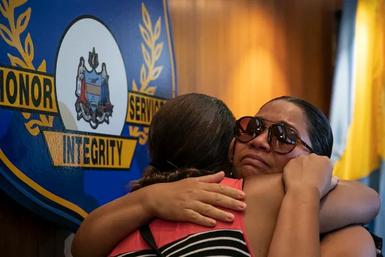 Kimberly Robinson, who lost her son, hugs Lisa Andino, who lost her stepson, during a news conference on the Philadelphia Police Department's new website for unsolved murders at police headquarters. The website, PhillyUnsolvedMurders.com, will help solicit tips and information of these unsolved murder cases.