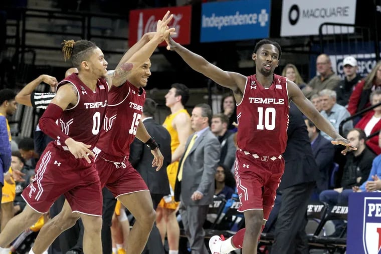 Shizz Alston (right) celebrates with teammates Alani Moore (left) and Nate Pierre-Louis after hitting a three-pointer in the first half of Temple's win over Drexel on Saturday.