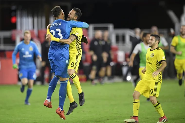 Columbus Crew SC goalkeeper Zack Steffen (23) celebrates with midfielder Artur (8) and defender Milton Valenzuela, right, after winning an MLS playoff soccer match in penalty kicks against D.C. United on Thursday.