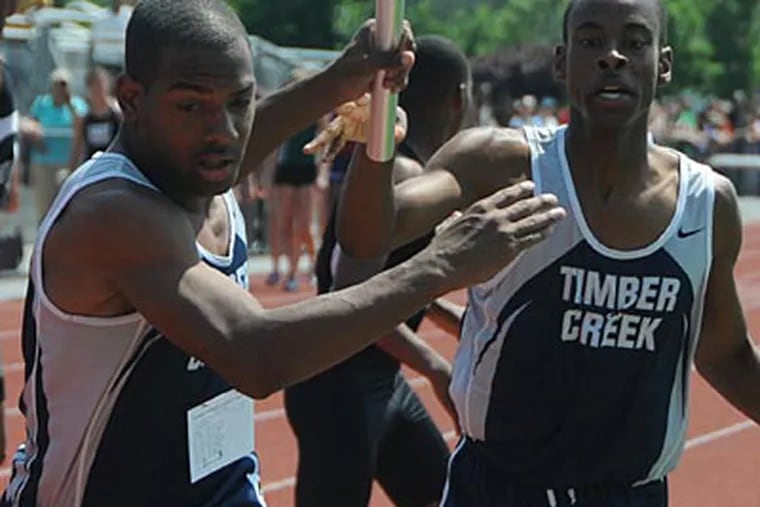Timber Creek's relay anchor Corey Harrity, left, takes the baton from
Greg Black. (Photo by Curt Hudson)
