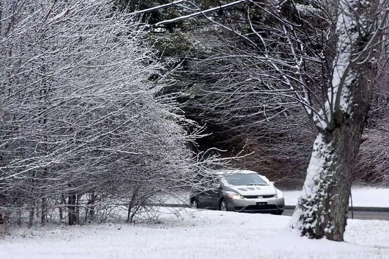 Snow covered cars pass fresh snow in Cherry Hill on Wednesday; might be awhile before it snows again.  TOM GRALISH / Staff Photographer