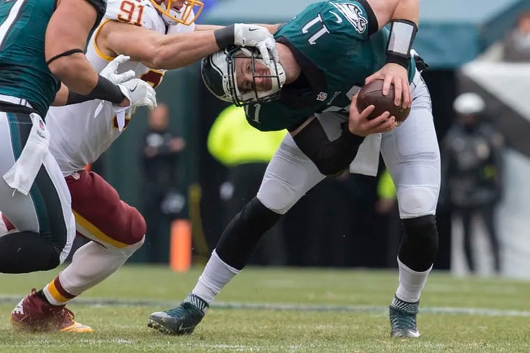 Carson Wentz, a rookie in this 2016 Eagles-Washington game, somehow escaped this attempted sack by Ryan Kerrigan.